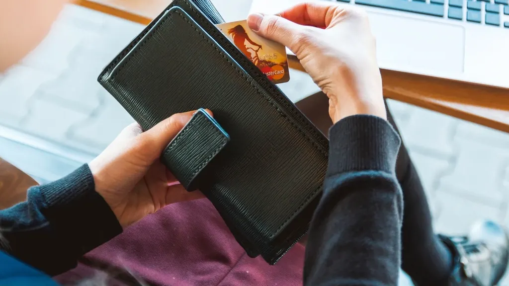 Pessoa comprando online com cartão de crédito no notebook